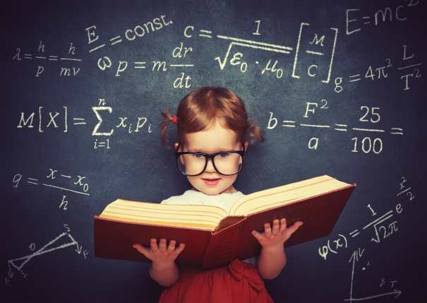 wunderkind little girl schoolgirl with a book from the blackboard with physical formulas